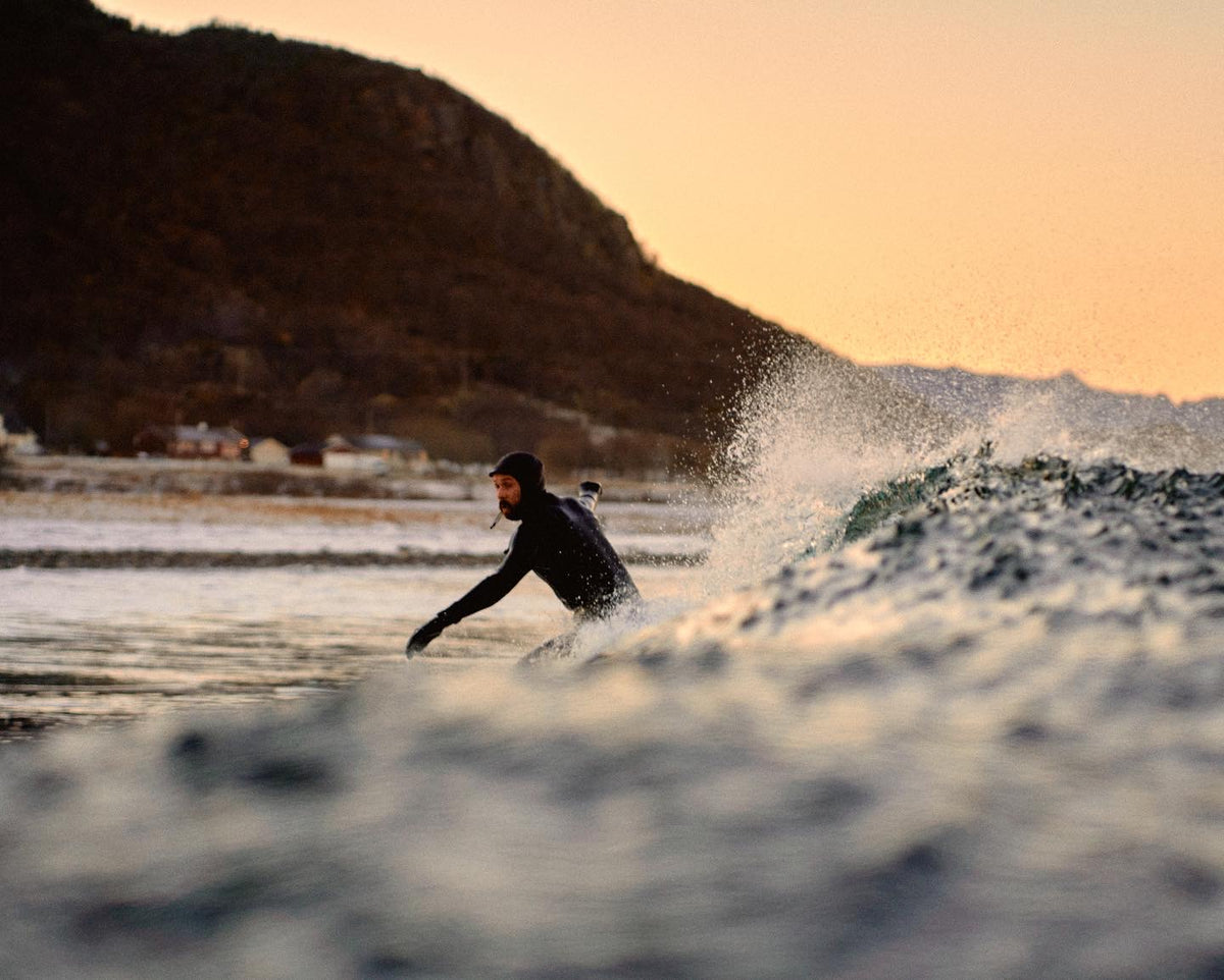 Surfer carving a wave in golden evening light